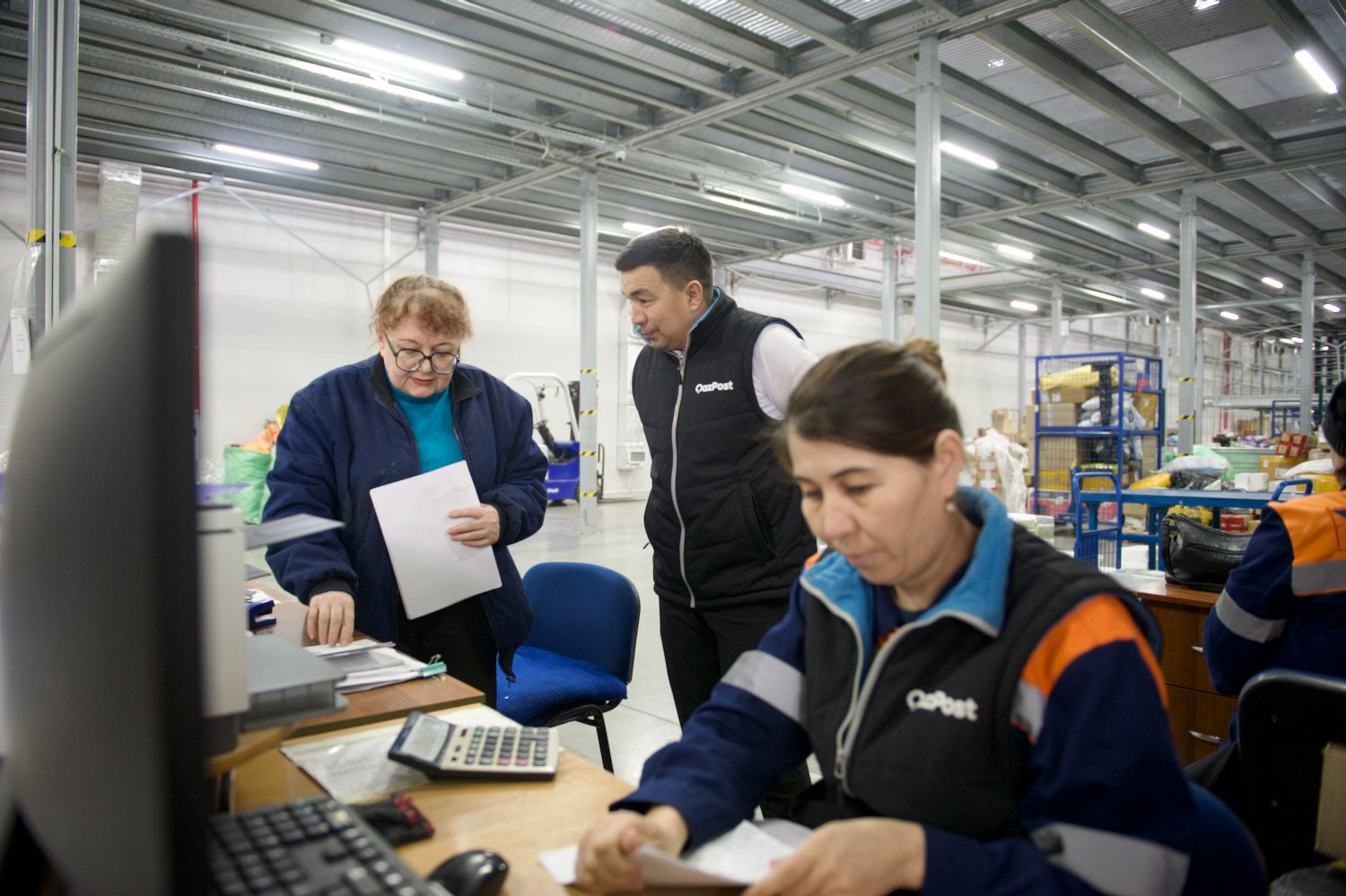 Сортировочный логистический центр АО «Казпочта» на складе Rainbow Logistics: сотрудники обрабатывают посылки в современном складском помещении, логистика, Казпочта, Rainbow Logistics, сортировка посылок, складской центр, доставка, почтовая логистика, сотрудники склада, обработка почты, Казахстан