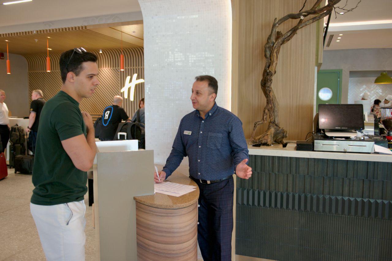 Команда Holiday Inn приветствует гостя в уютном лобби отеля: улыбка, чек-ин и профессионализм, Holiday Inn, гостеприимство, отель, сервис, путешествия Казахстан, лобби отеля, идеальный приём