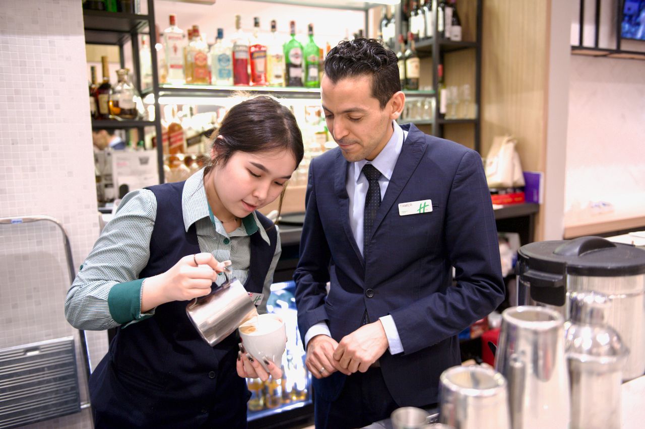 Команда Holiday Inn приветствует гостя в уютном лобби отеля: улыбка, чек-ин и профессионализм, Holiday Inn, гостеприимство, отель, сервис, путешествия Казахстан, лобби отеля, идеальный приём