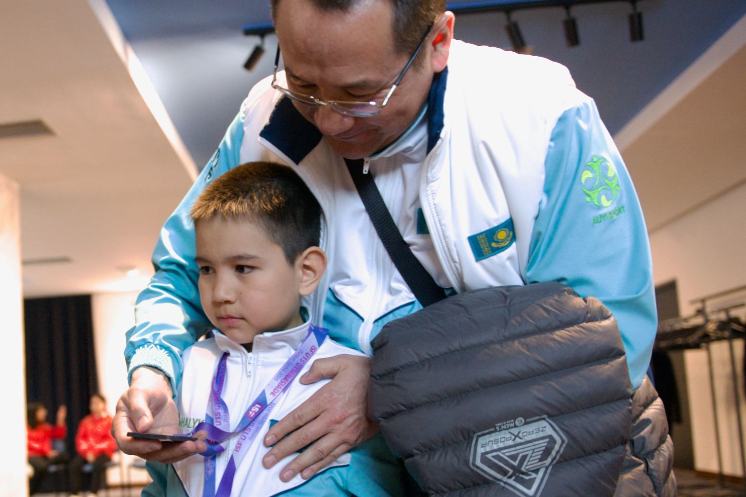 Участник проекта Auyl Sport из сельской местности Казахстана держит медаль и улыбается: путь от аула к чемпионству, Auyl Sport, фонд Halyk, сельские спортсмены, спорт в селе, Казахстан, агросело и спорт, проекты поддержки молодёжи, Тимур Кулибаев