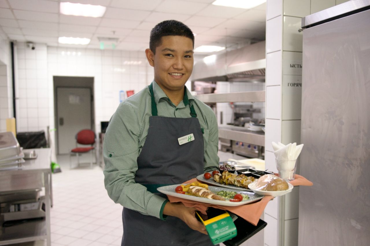 Команда Holiday Inn приветствует гостя в уютном лобби отеля: улыбка, чек-ин и профессионализм, Holiday Inn, гостеприимство, отель, сервис, путешествия Казахстан, лобби отеля, идеальный приём