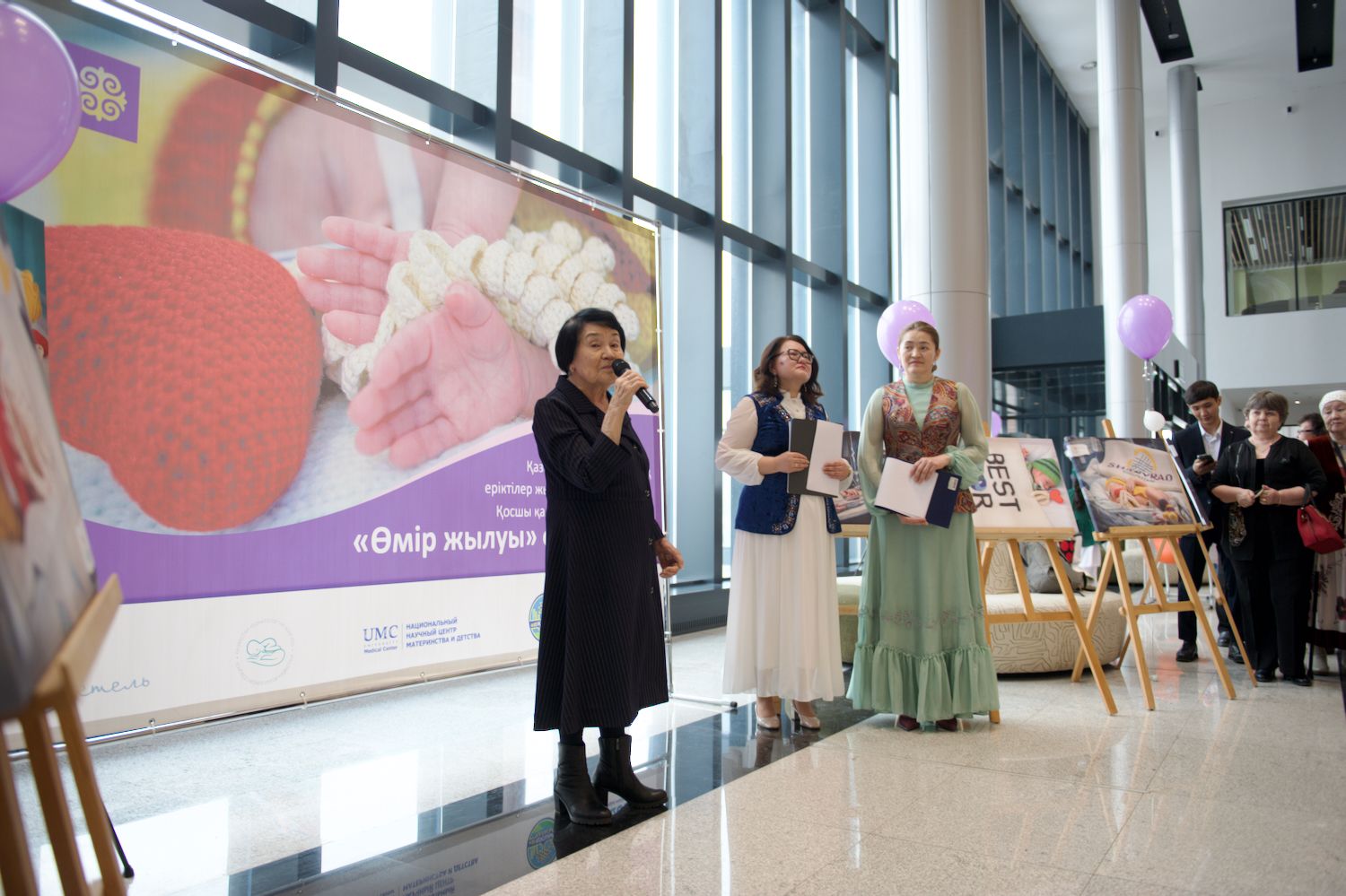 Қайырымдылық жобасының ашылуында Қазақстандағы Халықаралық волонтерлік жылын қолдауға арналған «Өмір жылуы» фотокөрмесінде Қосшы қаласындағы «28 ілмек» клубының қатысушылары мен қонақтары. «28 ілмек» клубы, Қосшы, Өмір жылуы, фотокөрме, волонтерлік, шала туған балалар, қайырымдылық, Қазақстан, Shanger.kz