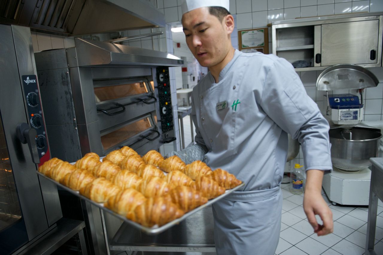 Команда Holiday Inn приветствует гостя в уютном лобби отеля: улыбка, чек-ин и профессионализм, Holiday Inn, гостеприимство, отель, сервис, путешествия Казахстан, лобби отеля, идеальный приём