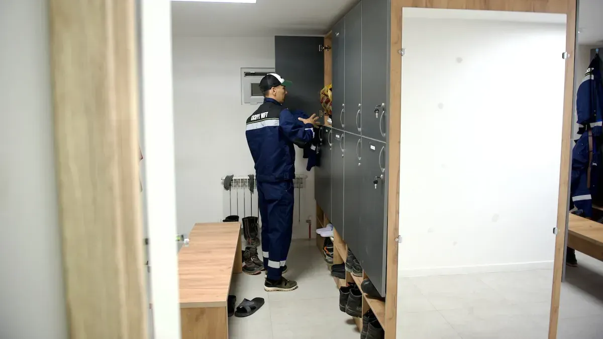 Работник Каспий Нефть переодевается в раздевалке перед сменой, каспий нефть, нефтяники, вахта, раздевалка, айранколь, подготовка к смене